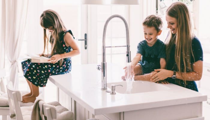 Family In Kitchen With Water Running Family In Kitchen With Water Running