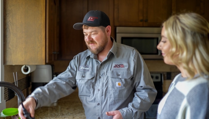 Plumber And Customer In Kitchen