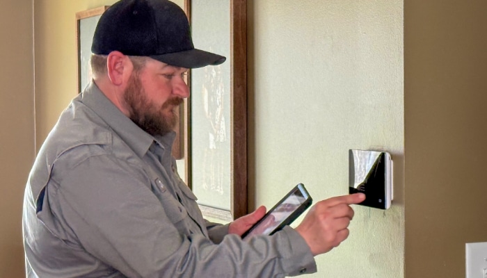 Technician Adjusting Thermostat