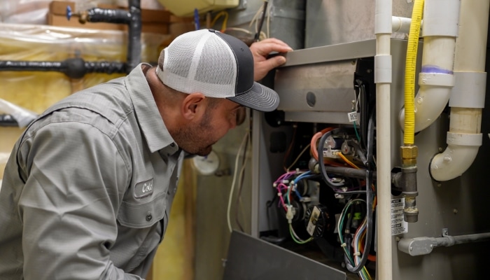 Technician With Furnace Panel Off
